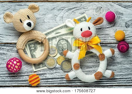 concept of starting forex traiding. small amount of money euro coins and us dollar banknotes and rattle knitted homemade toys for toddlers bulls and bears. education in foreign exchange trade.