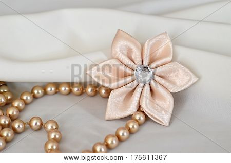 Handmade kanzashi flower and pearls on white background