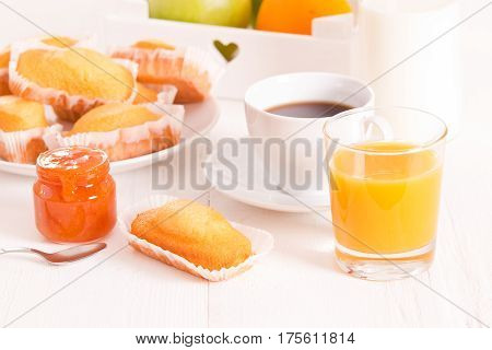 Breakfast with plumcake and orange juice on wooden table.