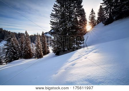 morning sunbeams over snowy hills in Alps