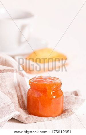Breakfast with plumcake and apricot jam on wooden table.