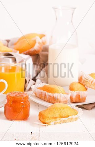 Breakfast with plumcake and orange juice on wooden table.
