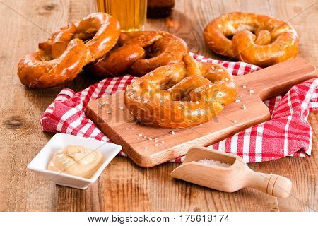 Bavarian pretzels with beer on wooden table.