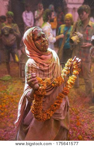 Vrindavan, India - March 21, 2016: An Indian widow celebrating Holi, the Hindu spring festival of colours, at Gopinath Temple in Vrindavan, Uttar Pradesh, India.