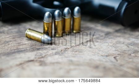 Bullets and a firearm on the wood. Bullets are a projectile expelled from the barrel of a firearm.