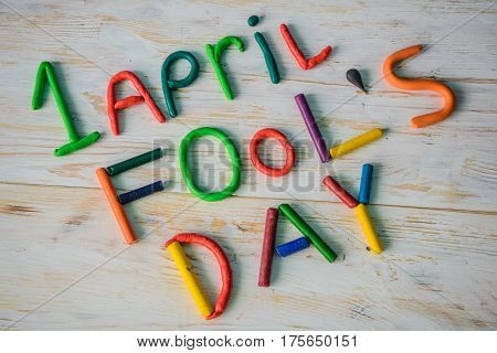 April Fools' Day text made with plasticine on white wooden background