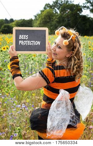 A woman dressed as a bee holds up a shield with bee protection