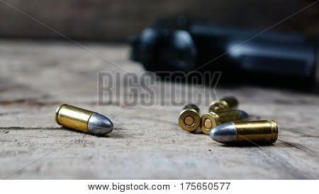 Bullets and a firearm on the wood. Bullets are a projectile expelled from the barrel of a firearm.