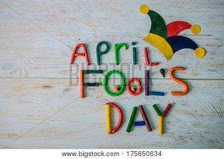 April Fools' Day text made with plasticine on white wooden background