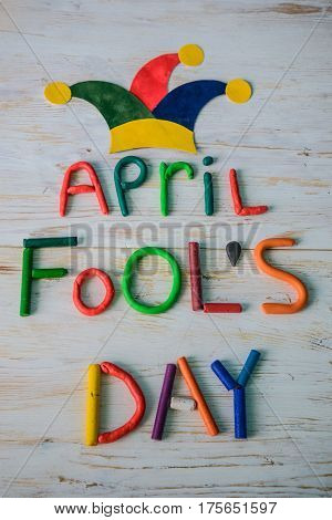 April Fools' Day text made with plasticine on white wooden background