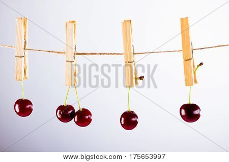 Red Cherry and rope on white with clamp fruit concept - desert, food