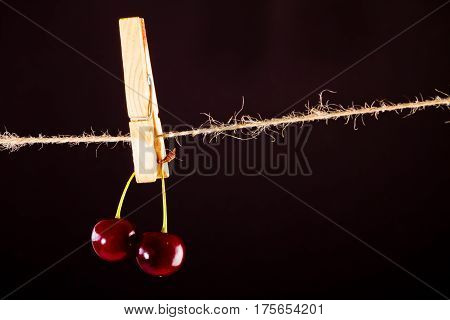 Red Cherry and rope on black with clamp fruit concept - desert, food