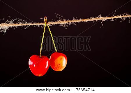 Red Cherry and rope on black with clamp fruit concept - desert, food