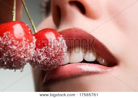 mladá žena ústa s červených třešní pokryté cukru