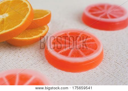 Exclusive orange handmade soaps. Fresh orange slices on the background.