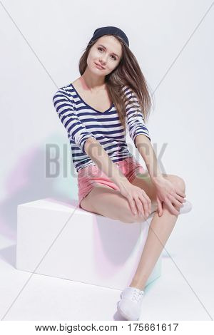 Lifestyle and Fashion Concepts. Portrait of Happy Smiling Sensual Caucasian Slim Brunette Girl Posing in Street Clothing Against White. Vertical Image Composition