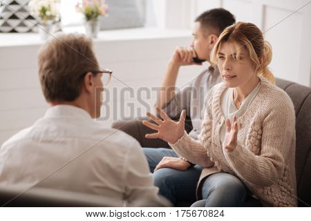 I cant live with him anymore. Gloomy unhappy blonde woman looking at the therapist and complaining about her husband while having problems in the relationship