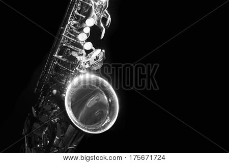 low key alto saxophone and light in the dark background black and white