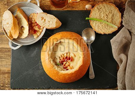 Delicious cream soup in bread on table