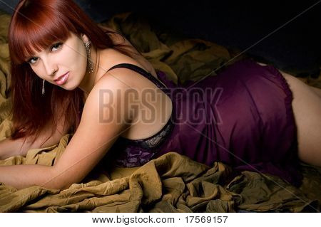 ผู้หญิงกระตุ้นความรู้สึกใน bedgown สวยงามกว่าฉากหลังพับ