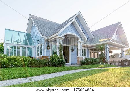 Bright Blue House In Sunlght With Colorful Poppies And Some Graceful Trees