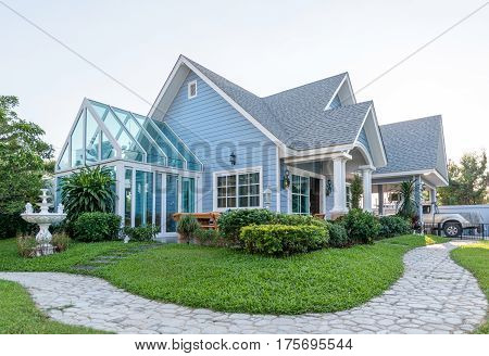 Bright Blue House In Sunlght With Colorful Poppies And Some Graceful Trees.
