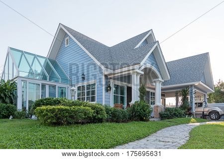 Bright Blue House In Sunlght With Colorful Poppies And Some Graceful Trees.