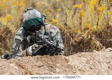 Machine gunner of 1st Marine Infantry Parachute Regiment RPIMA firing from defensive position trench