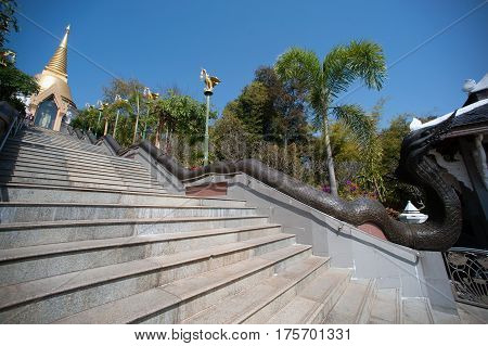 UDON THANI,THAILAND - JAN 25,2014:The Chedi Prathom Rattanamahaburaphachan above the steep staircase.The Chedi in Sri Lanka style, richly adorned with small golden mosaic stones,marble and granite ,in Wat Pa Phu Kon of Ban Na Kham,Na yung District in Udon