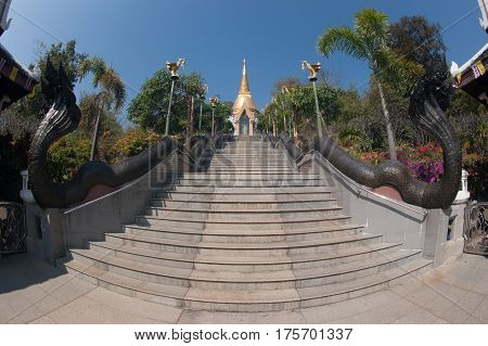 UDON THANI,THAILAND - JAN 25,2014:The Chedi Prathom Rattanamahaburaphachan above the steep staircase.The Chedi in Sri Lanka style, richly adorned with small golden mosaic stones,marble and granite ,in Wat Pa Phu Kon of Ban Na Kham,Na yung District in Udon