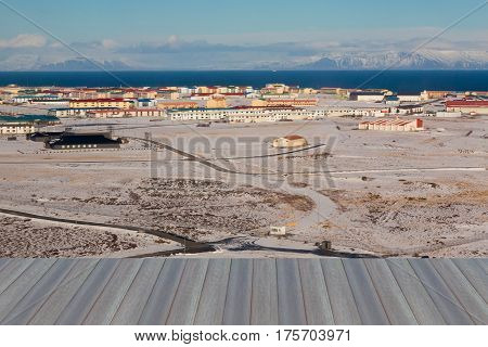 Opening wooden floor Icelandic small village over natural winter landscape background