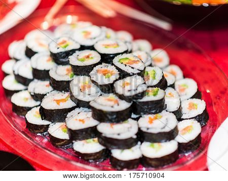 A plate full with salmon avocado sushi rolls.