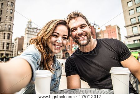 Couple dating in a coffeehouse bar in Manhattan - Tourists talking and having fun while sighseeing New York