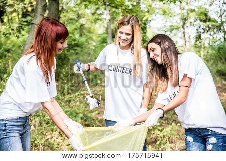Team of volunteers cleaning wood from trash