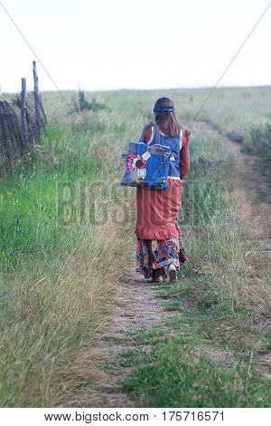 hippie girl goes away on a country road