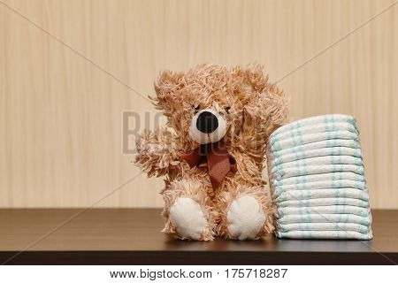 Stack of diapers or nappies with teddy bear closeup