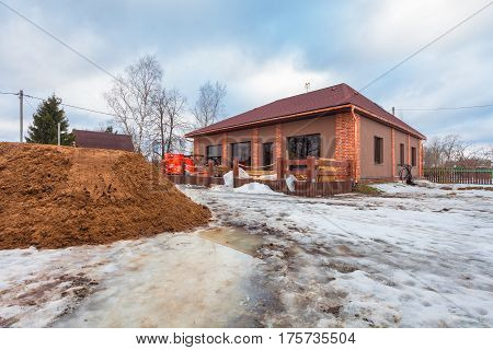 The modern house with terrace is under construction (remodel) and construction material for renovation are outside