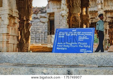 Hampi, India - November 19, 2012: Ancient Indian architecture for restoration. Sign about the restoration work in the courtyard of Vittala Temple in Hampi, Karnataka, India.