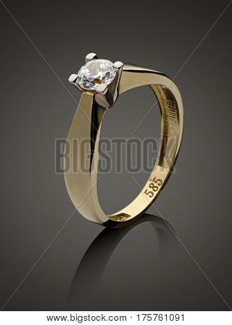 Gold ring with diamond on a dark background