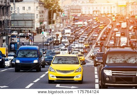 Heavy traffic on the city highway with yellow taxi car on the foreground