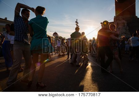 ST. PETERBURG, RUSSIA - CIRCA JULY, 2016: People dance to Latin music on the Spit of Vasilyevsky Island. Spit of Vasilyevsky Island is a popular place with locals and tourists. Focus in background.