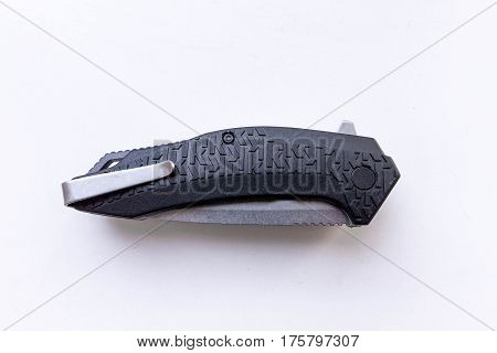 Knife folded. Knife with clip. Gray background.