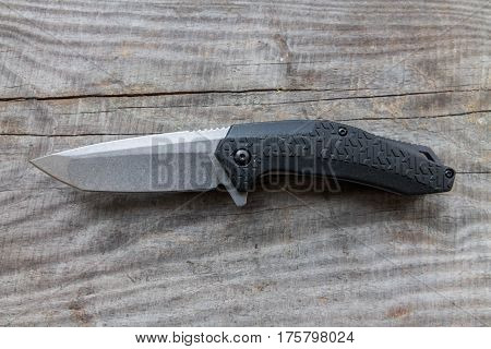 Knife with a plastic handle on a wooden background. Horizontal arrangement.