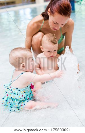 Baby playing in the water at indoor wsimming pool.