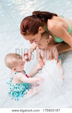 Baby playing in the water at indoor wsimming pool.