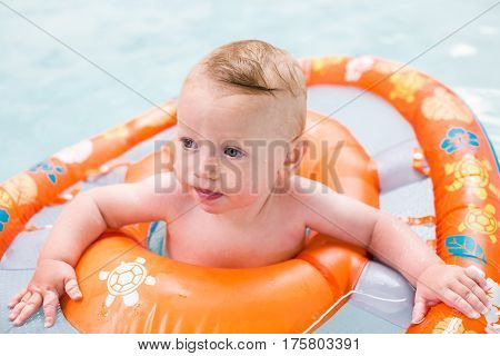 Baby playing in the water at indoor wsimming pool.