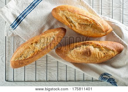 Freshly baked baguettes cooling on a rack.