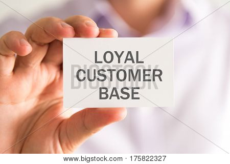 Businessman Holding A Card With Loyal Customer Base Message