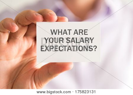 Businessman Holding A Card With What Are Your Salary Expectations Message