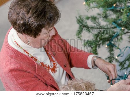 Family decorating beautiful live Christmas tree .